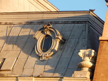Low angle view of sculptures on building against sky
