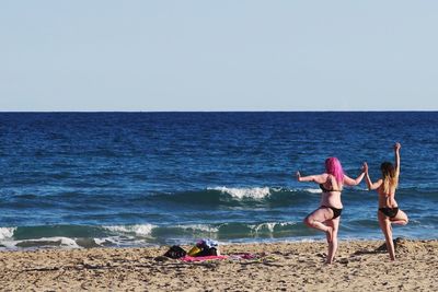 Bikini women standing on calm beach