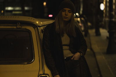 Portrait of young woman standing at night