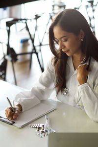 Doctor writing on clipboard at hospital