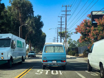 Cars on road against trees in city