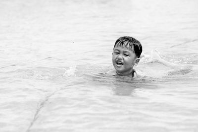 Portrait of shirtless boy swimming in pool
