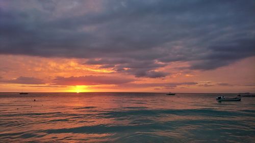 Scenic view of sea against dramatic sky during sunset