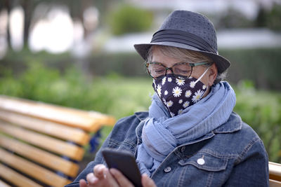 Portrait of woman using mobile phone in park