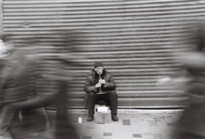 People sitting on wall in city