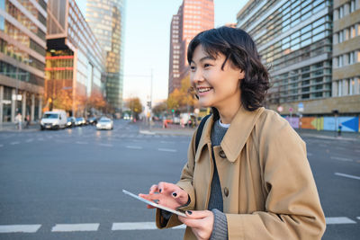 Young woman using mobile phone in city