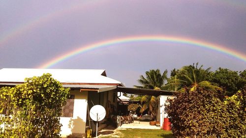 Rainbow over street and buildings against sky