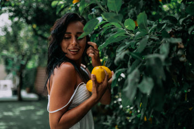 Young woman standing against orange plants