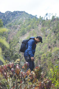 Hipster young boy with backpack enjoying trekking sunset on the mountains. tourist traveler .