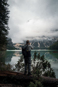 Man standing by lake against sky