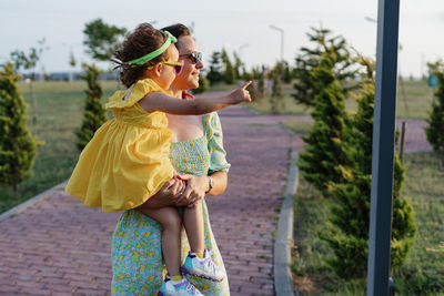 Rear view of woman standing by railing