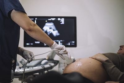 Female gynecologist doing ultrasound of pregnant woman in hospital