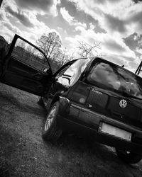 Abandoned car on field against sky