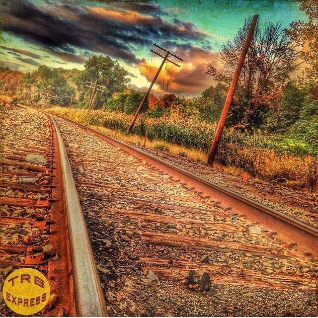railroad track, transportation, tree, sky, rail transportation, the way forward, cloud - sky, nature, diminishing perspective, sunset, tranquility, tranquil scene, outdoors, vanishing point, landscape, no people, road, scenics, beauty in nature, yellow