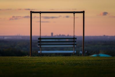 Lifeguard hut on field against sky during sunset