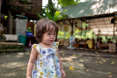 Cute toddler girl standing on footpath