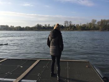 Rear view of man on lake against sky