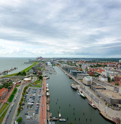 High angle view of cityscape by sea against sky