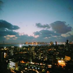 Illuminated cityscape against sky at night