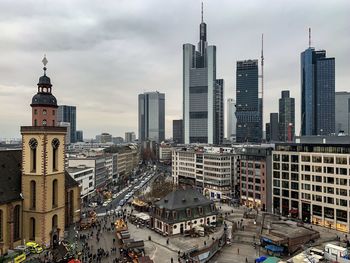 Modern buildings in city against cloudy sky