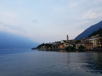 Scenic view of sea by town against sky