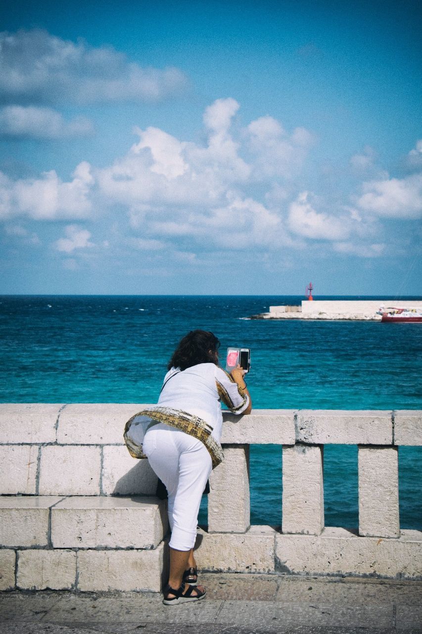 water, sky, sea, rear view, full length, real people, one person, cloud - sky, horizon, lifestyles, nature, horizon over water, day, beauty in nature, scenics - nature, women, leisure activity, wall, outdoors, looking at view