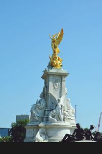 Low angle view of statue against blue sky