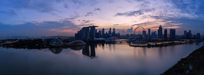 Panoramic view of river and buildings against sky during sunset