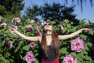 A young woman posing in front of a bush