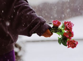 Close-up of hand holding rose bouquet