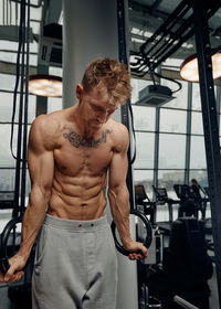 Shirtless muscular man exercising in gym