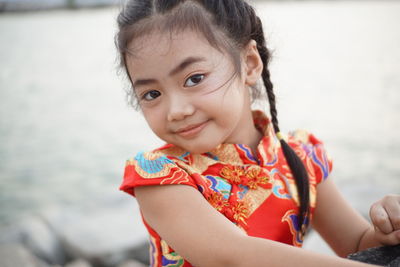 Portrait of smiling cute girl against sea
