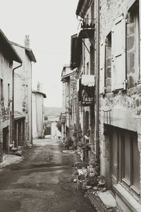 Alley amidst houses against clear sky