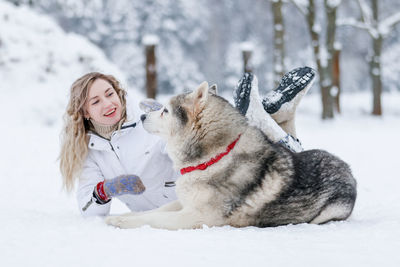 Young woman with dog in snow