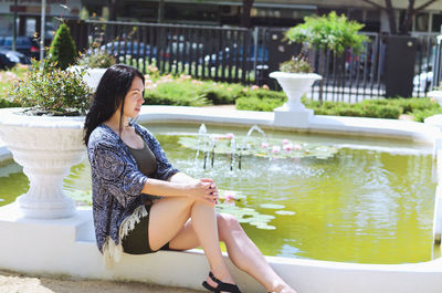 Young woman sitting in swimming pool