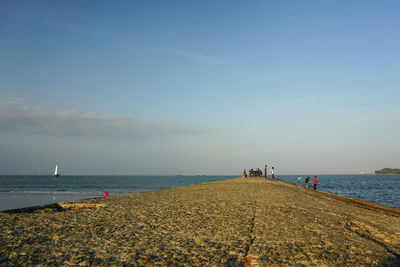 People on beach against sky