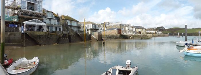 Panoramic view of buildings by river against sky