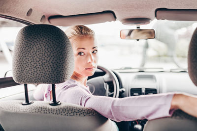 Rear view of woman sitting in car