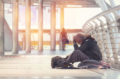 Side view of woman sitting on floor