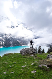 Man standing on rock against sky