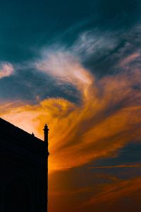 Low angle view of silhouette building against dramatic sky