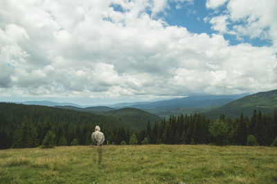 Digital composite image of man standing on field against sky