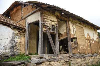 Low angle view of abandoned house against sky