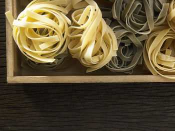 Directly above shot of tagliatelle pasta in crate on table