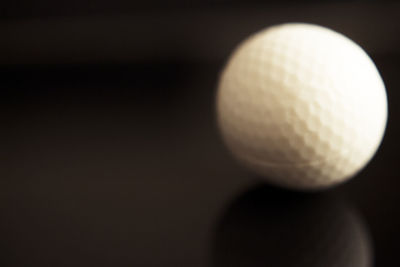 Close-up of ball on table against black background