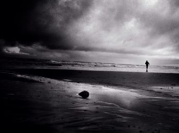 Scenic view of beach against cloudy sky