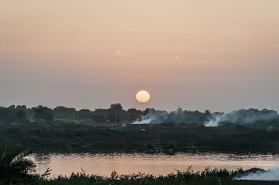 Scenic view of lake against sky during sunset