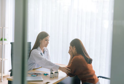 Female doctor sitting with patient in clinic