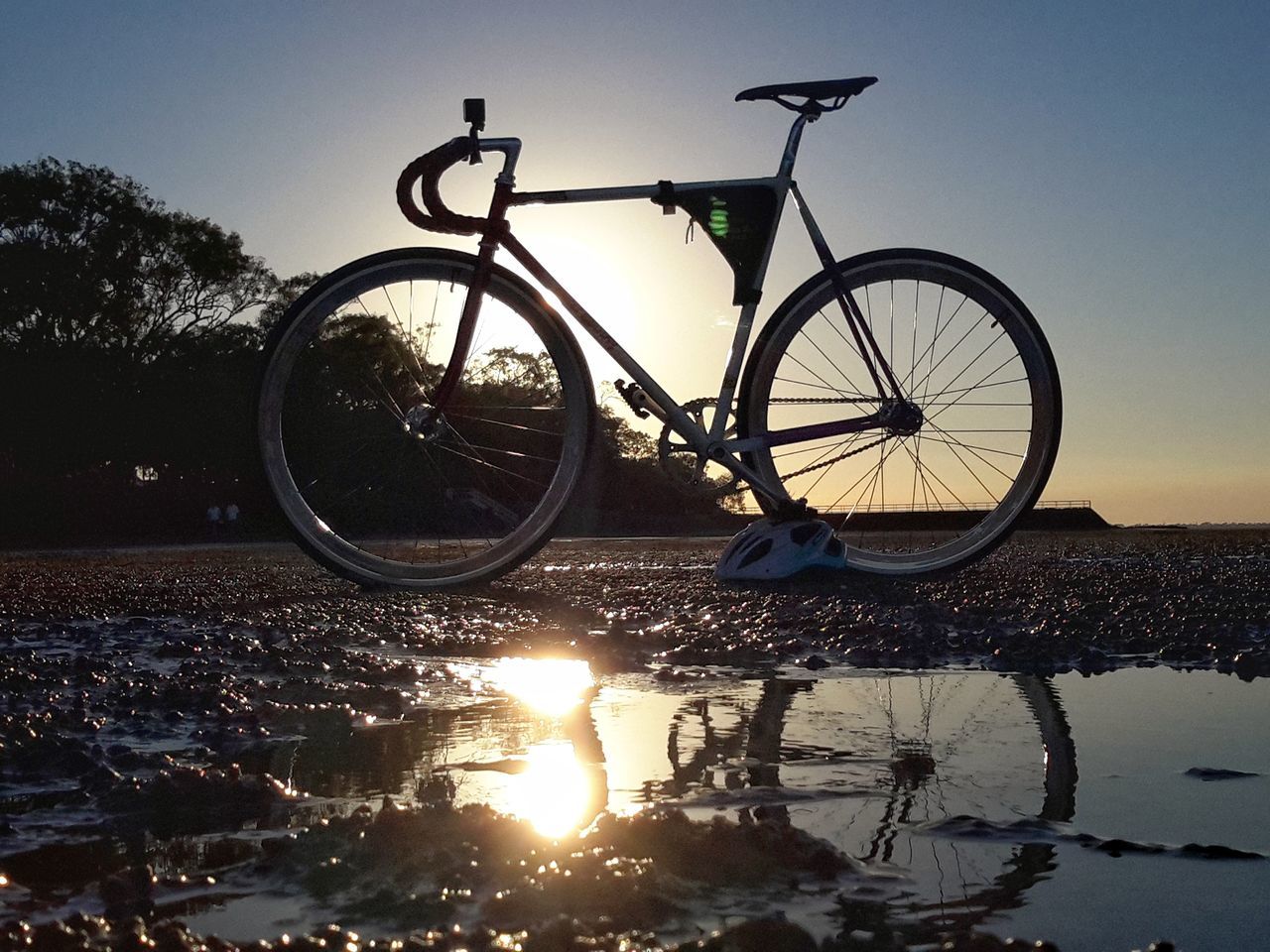 BICYCLES PARKED BY WATER AGAINST SKY