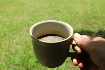 Midsection of person holding coffee cup